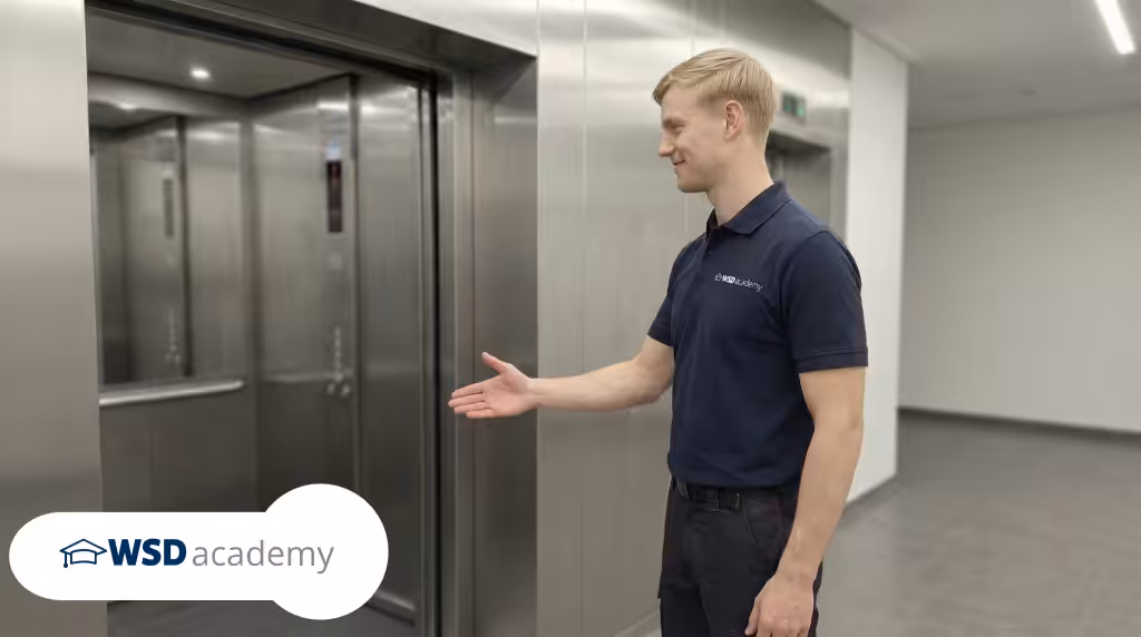 Aufzugsbefreier der WSD Academy steht vor einem Aufzug und erklärt die sichere Personenbefreiung
